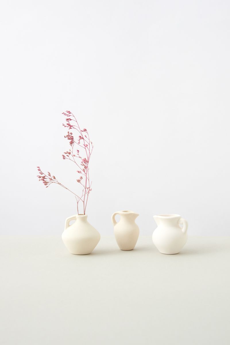Sculptural cream ceramic vessels on a pale background